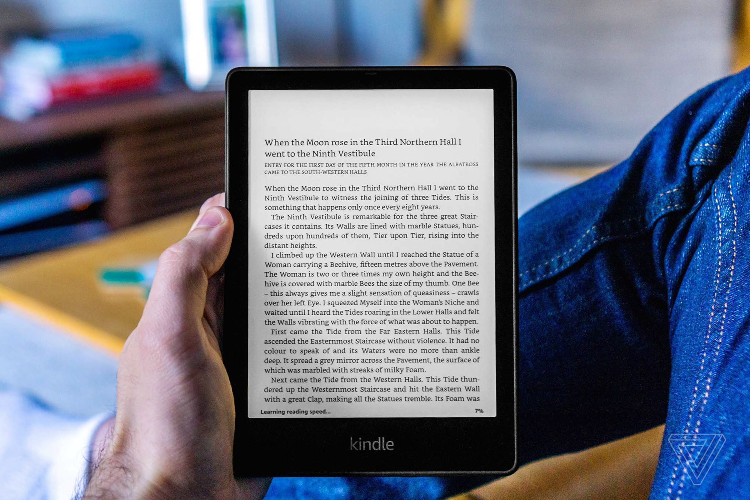 A hand holding up the Kindle Paperwhite