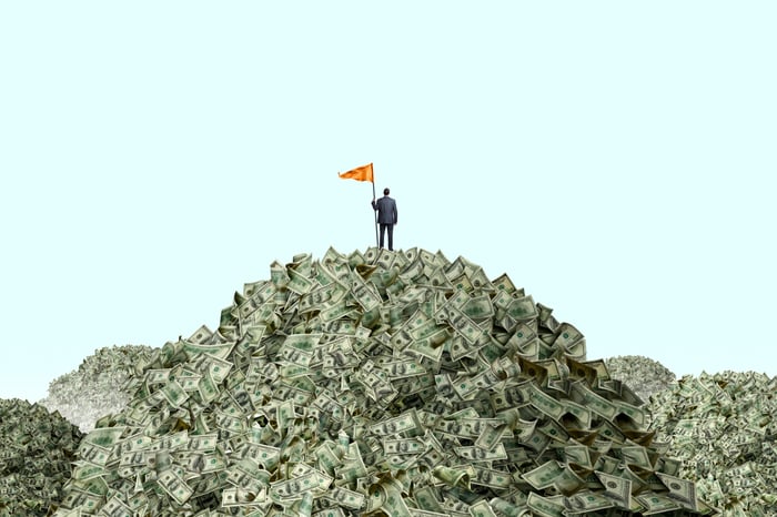 Person standing on mountain of cash.