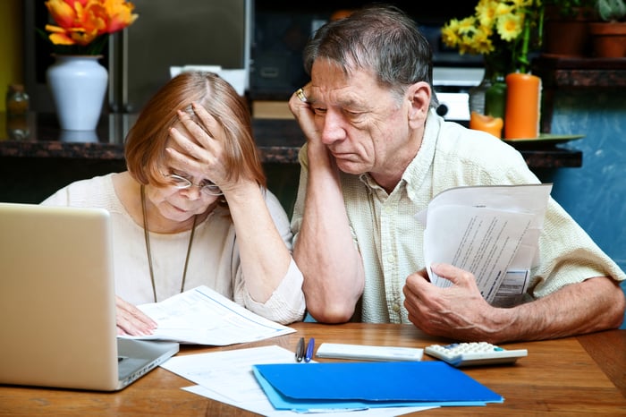 Two people with concerned expressions looking at a document.