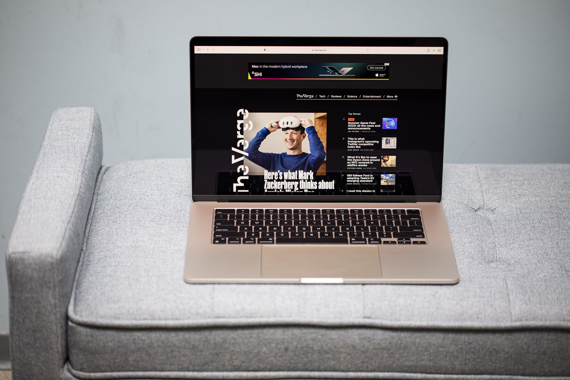 A 15-inch MacBook Air open on a gray couch.