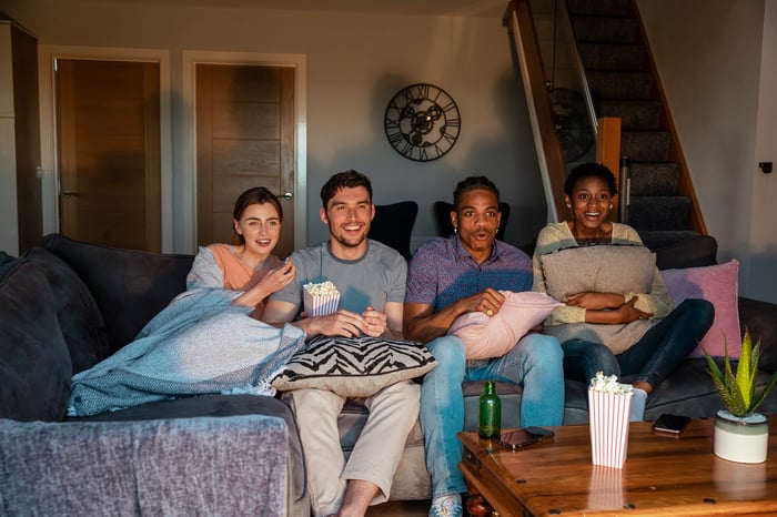 A group of friends watching a movie at someone's house.