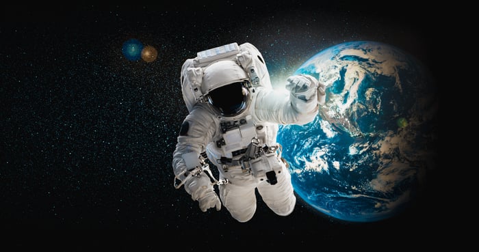 Astronaut in a space suit in space over Earth.